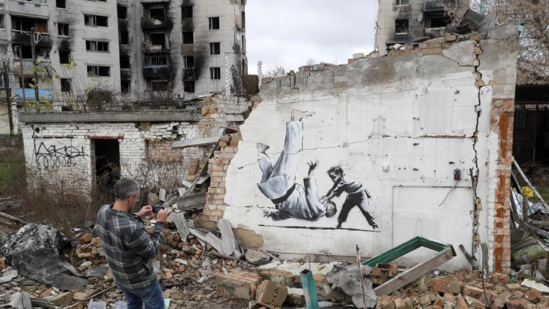 Un mural de Banksy que representa a un niño derribando a un hombre vestido de judo, en una pared de un edificio que fue destruido durante un bombardeo en Borodyanka, Ucrania, 13 de noviembre de 2022.