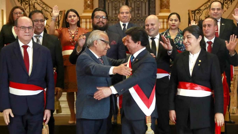 Fotografía cedida por la Presidencia del Perú que muestra al presidente Pedro Castillo (c) mientras saluda al ex primer ministro Aníbal Torres (2-i) y rodeado de su nuevo gabinete de ministros, en Lima