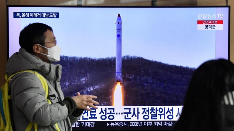 Un hombre frente a una televisión que muestra una transmisión de noticias con imágenes de archivo de una prueba de misiles de Corea del Norte el 31 de diciembre de 2022.