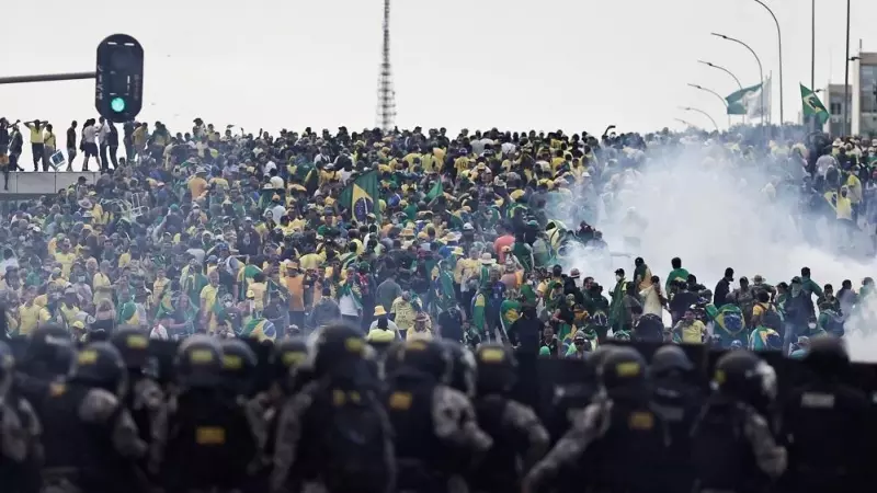 Los policías observan a los miles de seguidores ultras de Bolsonaro que han asaltado el Congreso de Brasil.