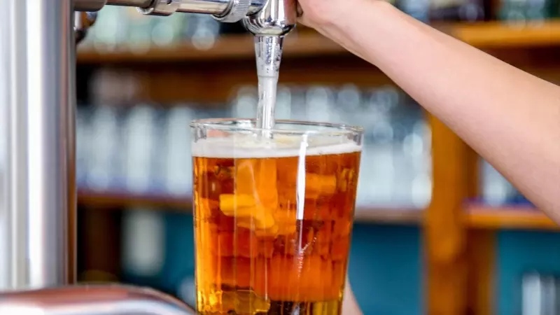 Imagen de archivo de un camarero mientras tira una cerveza en un bar.