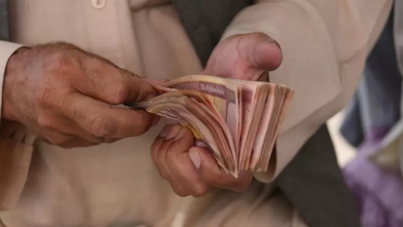 Un hombre cuenta efectivo en un mercado de cambio de dinero en Kabul, Afganistán