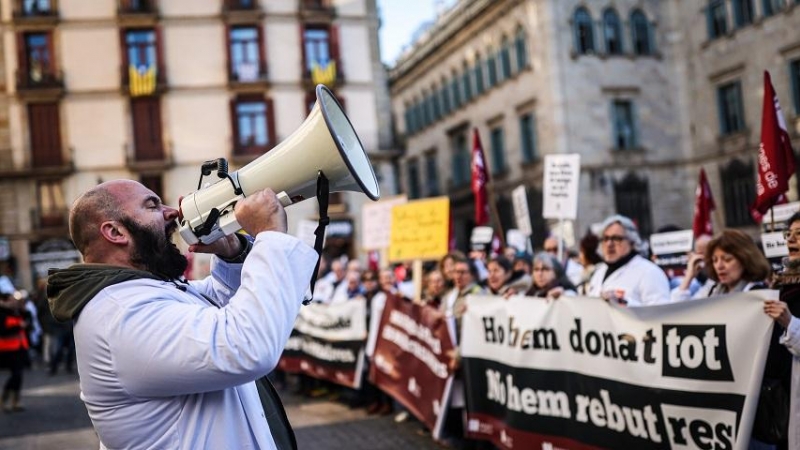 Un facultatiu crida proclames en la manifestació convocada per Metges de Catalunya a la plaça Sant Jaume.