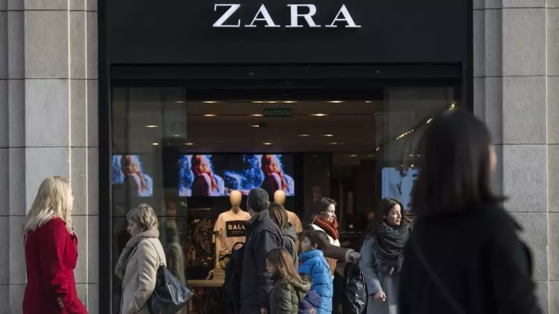Varios transeúntes pasan por delante de una tienda de Zara anunciando descuentos en el primer día de las rebajas de invierno en Barcelona. el 7 de enero de 2017.