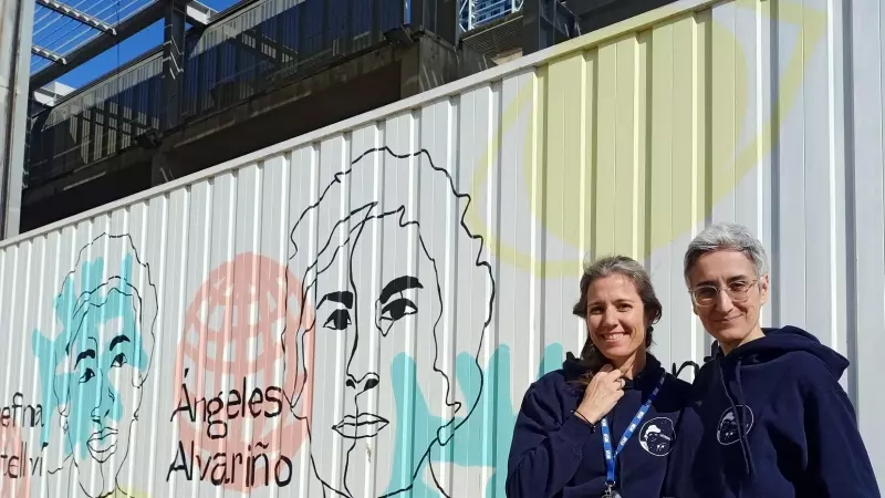 Ribas i Sabaté davant d'un mural de dones científiques.
