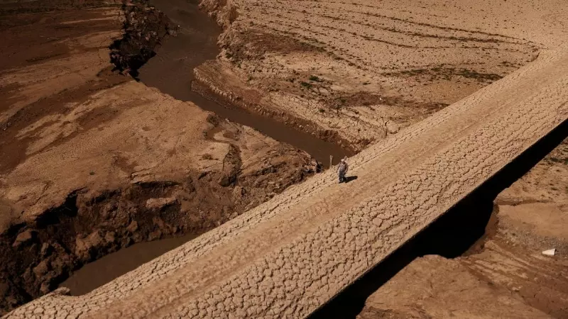 Un hombre camina sobre el suelo agrietado del embalse de Baells, en Catalunya, mientras el suministro de agua potable ha caído a su nivel más bajo desde 1990 debido a la sequía extrema.
