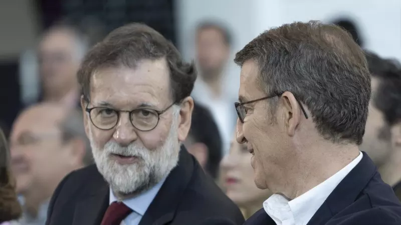 El expresidente del Gobierno Mariano Rajoy (i) y el presidente del Partido Popular, Alberto Núñez Feijóo (d), conversan durante la clausura de la 26 Intermunicipal del Partido Popular (PP), a 5 de febrero de 2023, en Valencia