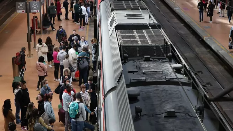 Numerosas personas con maletas esperan en el andén la salida de un tren, en la estación Almudena Grandes-Atocha, en Madrid, a 31 de marzo de 2023.