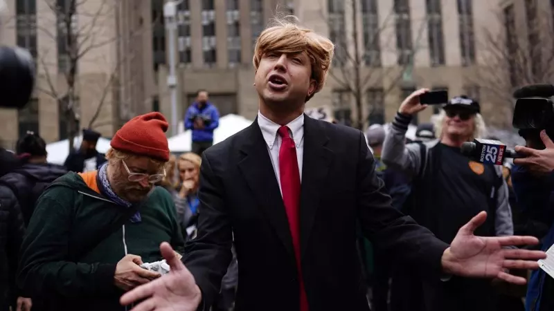 Un imitador de Donald Trump rodeado de periodistas a las afueras del juzgado de Nueva York donde se leerán los cargos al expresidente, a 4 de abril de 2023.