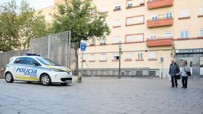 Dos personas mayores pasan junto a un coche de policía municipal, a 22 de octubre de 2022, en Madrid.