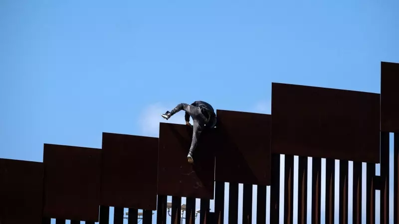 Un hombre trata de cruzar una de las vallas que separa los territorios estadounidenses y mexicanos, en Tijuana, Baja California, a 10 de mayo de 2023.