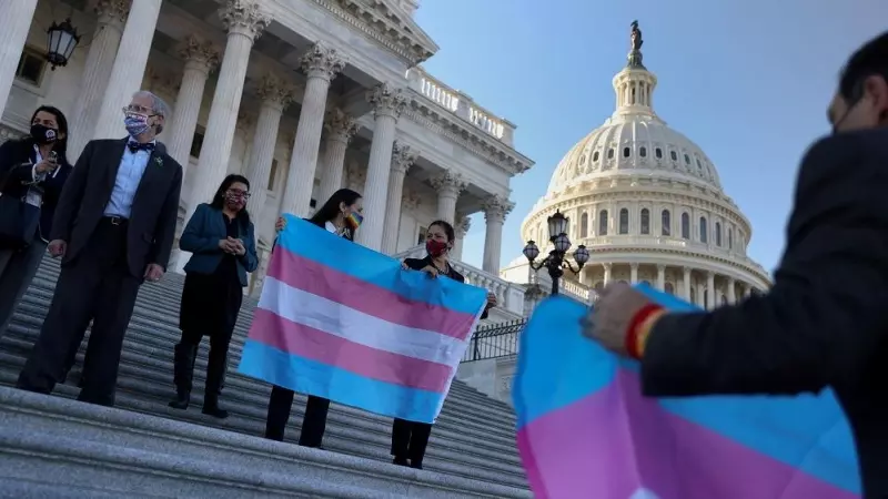 Varias personas ondean una bandera transgénero en el Capitolio de EEUU, el 25 de febrero de 2021.