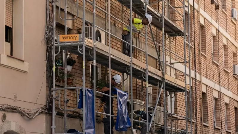 Un trabajador subido a los andamios de una obra, a 17 de mayo de 2023, en Barcelona.