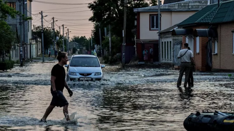 La gente camina en una calle inundada de Kherson, Ucrania, el 6 de junio de 2023.