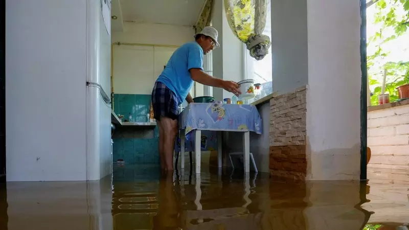 El residente local Valery, de 53 años, que no dio su apellido, coloca una cacerola en la cocina de su casa que se sumergió en agua.