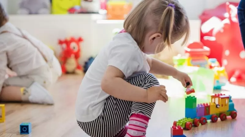 Una niña juega con el tren de madera en una escuela (Archivo)