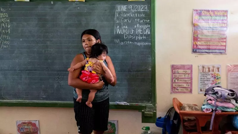 06/11/2023 - Elena Rosales, 23, holds her daughter inside a classroom converted into an evacuation site after the Mayon volcano alert level was raised, in Daraga, Albay province, Philippines, June 11, 2023. June 2023.