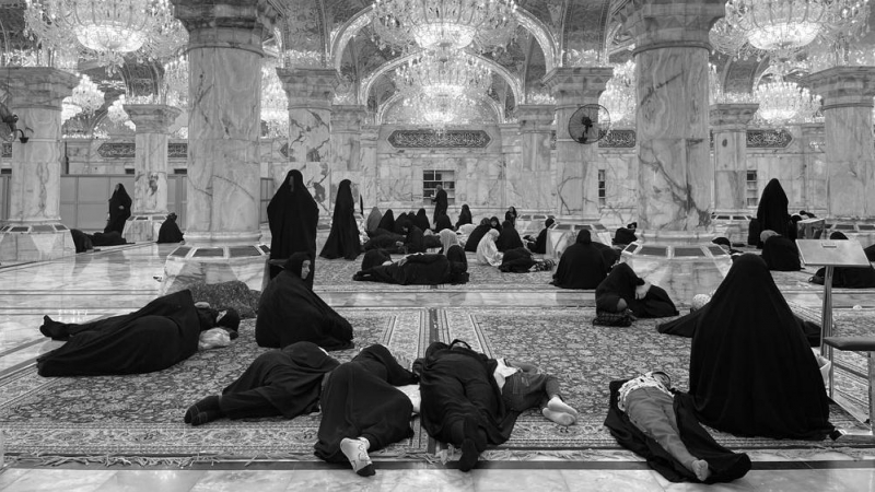 Decenas de mujeres vestidas con abaya descansan tumbadas en el suelo con algunas niñas en el santuario de Husein, en Kerbala (Irak).