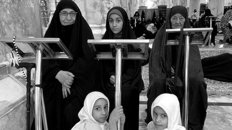 Mujeres de varias edades, junto a niñas sentadas en el santuario de Ali, en Nayaf (Irak).