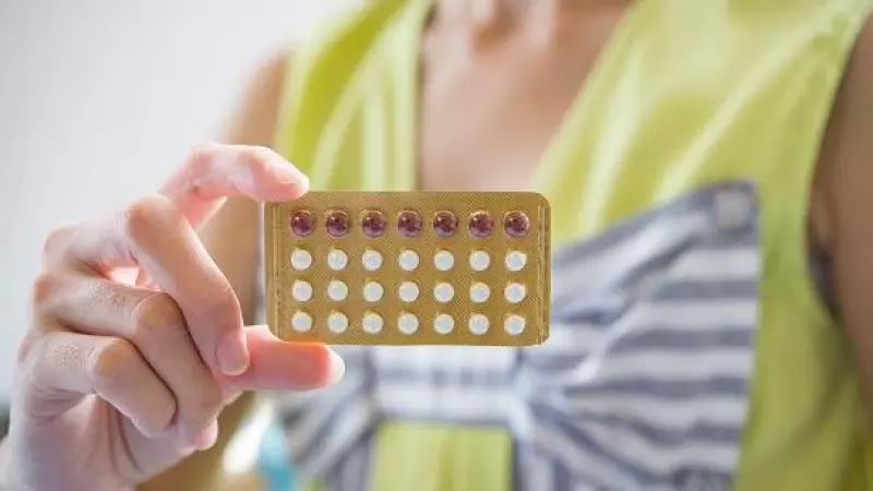 Una mano de mujer sosteniendo un panel de pastillas anticonceptivas (archivo)