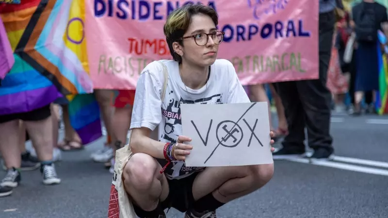 Una persona sujeta un cartel con las letras de Vox tachadas durante el Orgullo Crítico en Madrid.