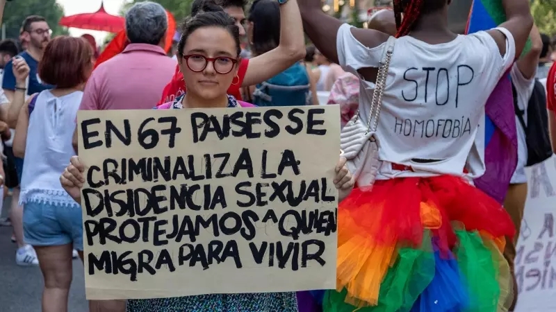Una mujer sujeta una pancarta por la protección de las personas LGTBI que escapan de sus países a causa de su condición.