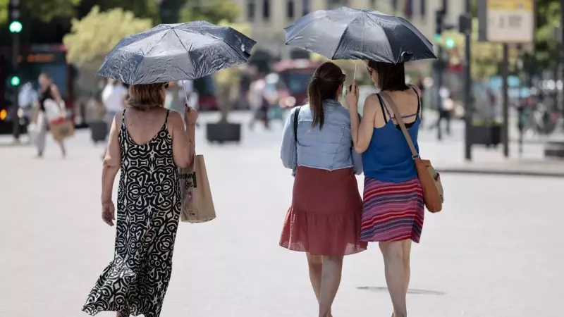 Tres mujeres se protegen del calor con unos paraguas en Valéncia a 4 de julio de 2023.