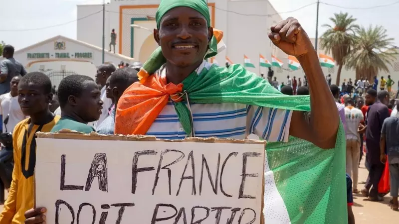 Un manifestante carga una pancarta que dice: 'Los franceses deben partir'