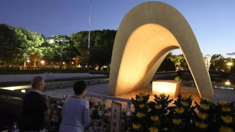 Dos personas rezan ante el Parque Conmemorativo de la Paz, en Hiroshima, en recuerdo a las víctimas de la bomba atómica este 6 de agosto de 2023.