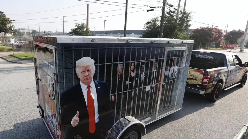 Un seguidor del expresidente estadounidense Donald Trump con un remolque que muestra imágenes de líderes demócratas en una celda, a las puertas de la cárcel del condado de Fulton, en Atlanta, Georgia, este 24 de agosto de 2023.
