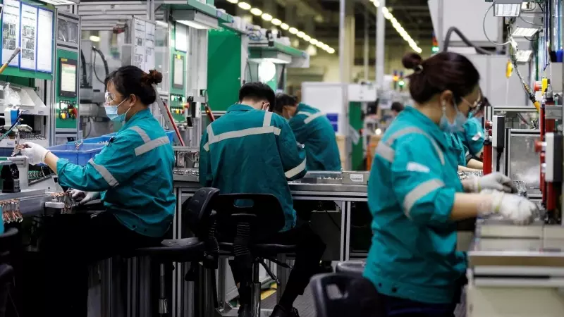 Trabajadores en la línea de producción de una planta de componentes electrónicos de Pekín. REUTERS/Florence Lo
