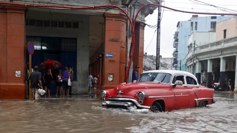 Un carro transita hoy por una calle inundada, en La Habana, Cuba, a 29 de agosto de 2023.