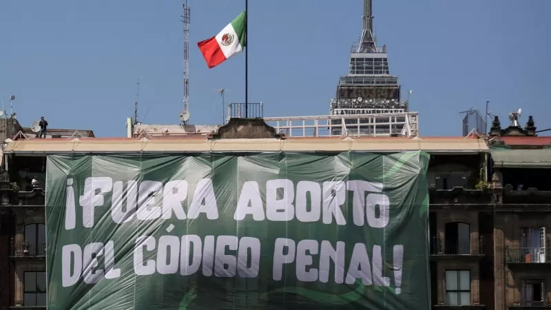 Una pancarta que dice: 'Aborto fuera del Código Penal' cuelga de un edificio durante el Día Internacional de la Mujer, en la Plaza del Zócalo en la Ciudad de México, México, el 8 de marzo de 2023.