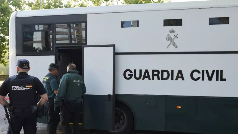 Varios agentes de la Guardia Civil y de Policía Nacional junto a un autobús de la Guardia Civil.