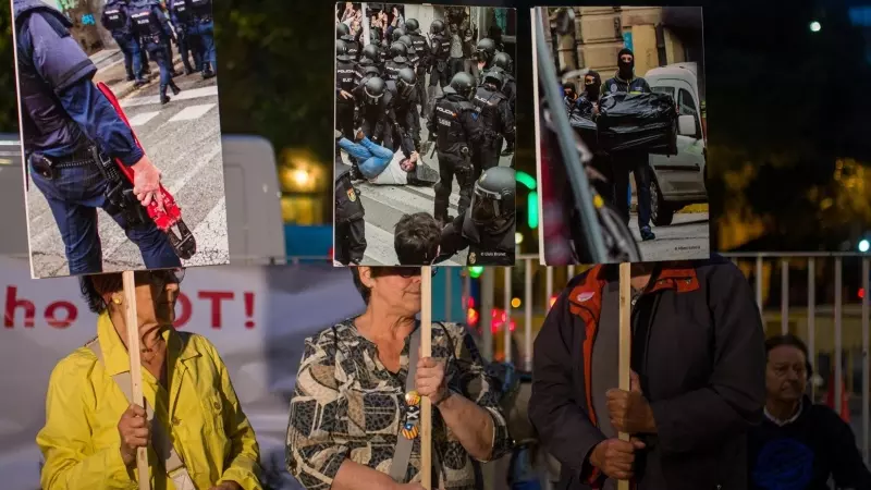 Varias personas con carteles de agentes de policia durante una movilización nocturna en el Institut Balmes, a 30 de septiembre de 2022, en Barcelona
