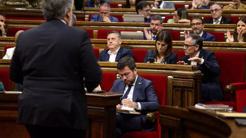 El president de Junts al Parlament, Albert Batet, torna al seu escó passant pel costat del president de la Generalitat, Pere Aragonès