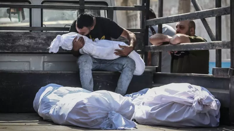 Un palestino besa el cuerpo de un niño muerto durante los ataques aéreos israelíes, frente a la morgue del hospital al-Shifa en la ciudad de Gaza, a 12 de octubre de 2023.