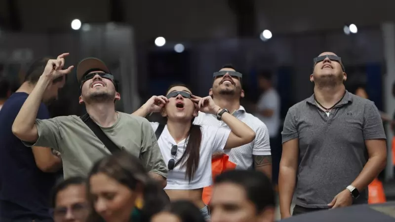 Ciudadanos observan el eclipse anular de sol hoy, desde Cali (Colombia).