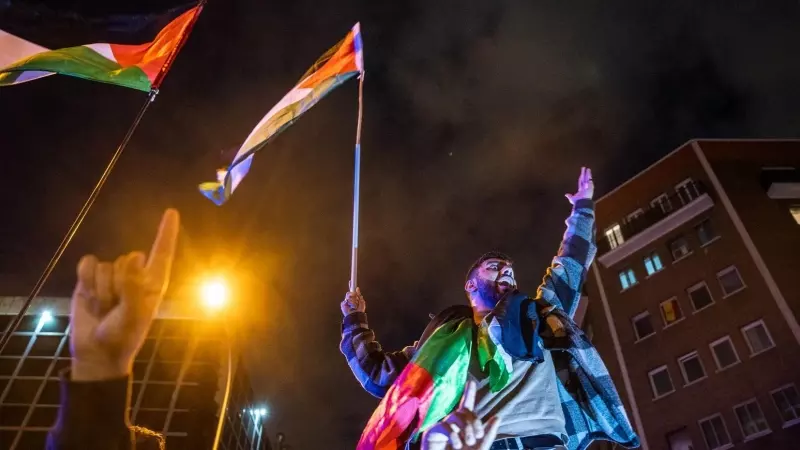 Manifestante grita sosteniendo una bandera palestina, durante una concentración de emergencia por los últimos acontecimientos en Gaza, frente a la embajada Israelí, a 18 de octubre de 2023