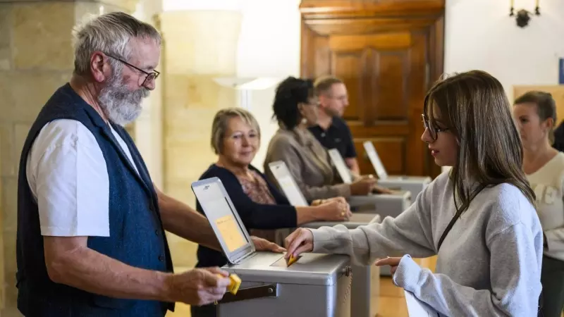 Una mujer deposita su voto en Delemont durante las elecciones federales suizas.