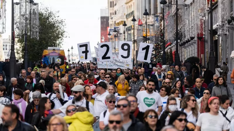 Varias personas llevan carteles que indican el número de fallecidos en residencias en la pandemia, durante una manifestación convocada por Marea de Residencias, en Madrid, a 26/11/2023