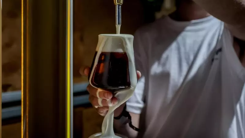 Imagen de archivo de un camarero tirando una cerveza negra de barril, a 28 de mayo de 2022 en Madrid.