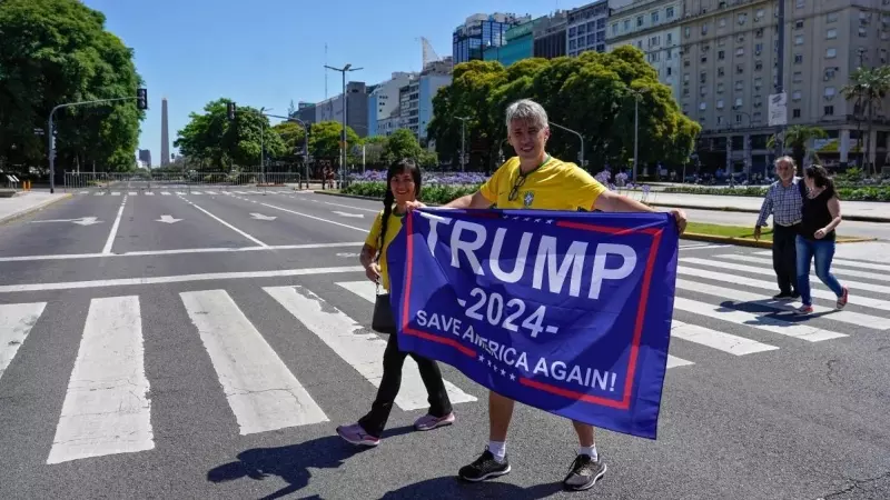 Una pareja que sostiene una bandera del expresidente estadounidense Donald Trump asiste a la ceremonia de toma de posesión de Javier Milei, en Buenos Aires, a 10/12/2023