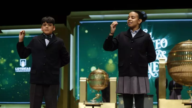 Dos niños de San Ildefonso cantan el primer quinto premio del sorteo, el 54274, durante el sorteo extraordinario de Navidad de la Lotería Nacional este viernes en el Teatro Real de Madrid.