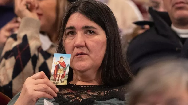 Una mujer sujeta la foto de una virgen durante la celebración del Sorteo Extraordinario de la Lotería de Navidad 2023 en el Teatro Real de Madrid, a 22 de diciembre de 2023.