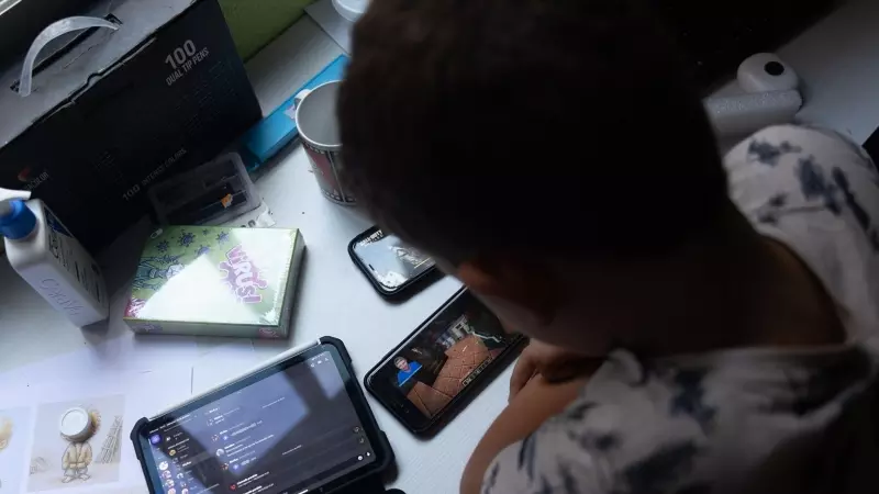 Un niño usa el teléfono móvil y una tablet, a 18 de octubre de 2023, en Madrid (España).