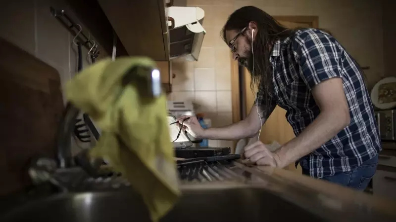 Un hombre teletrabaja desde su casa con un portátil mientras cocina, en Madrid (España), a 11 de septiembre de 2020.