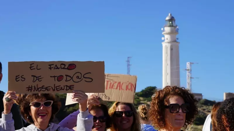 Varias personas protestando contra  la apertura de un restaurante en el faro de Trafalgar
