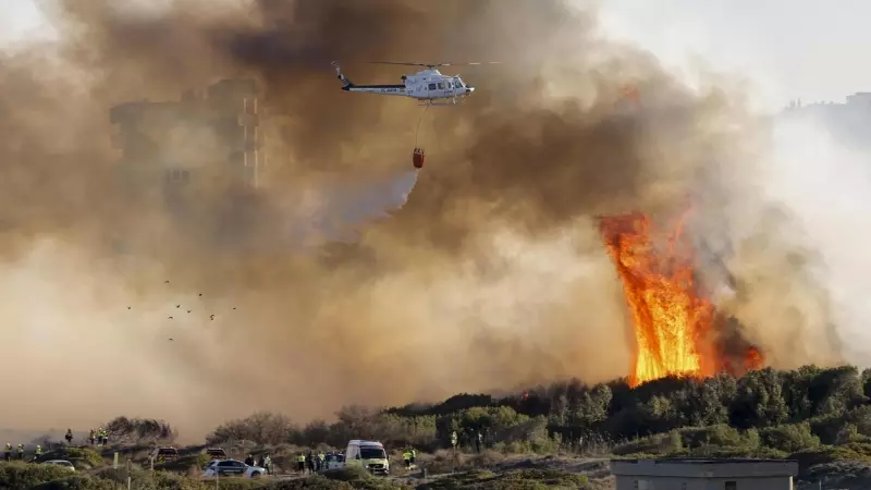 Un helicóptero trabaja en las labores de extinción del incendio forestal declarado en El Saler, en València, a 12 de febrero de 2024.