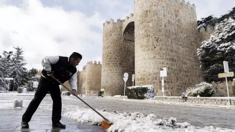 Un hombre limpia la calle de nieve frente a las murallas de Ávila (España) el 3 de marzo de 2024.